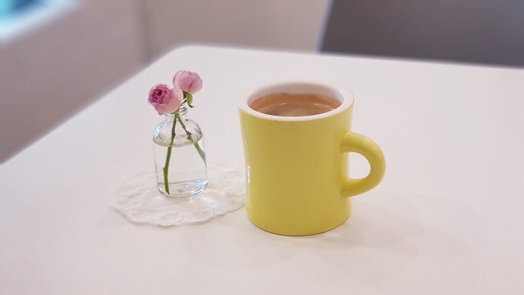 机の上のコーヒーとお花